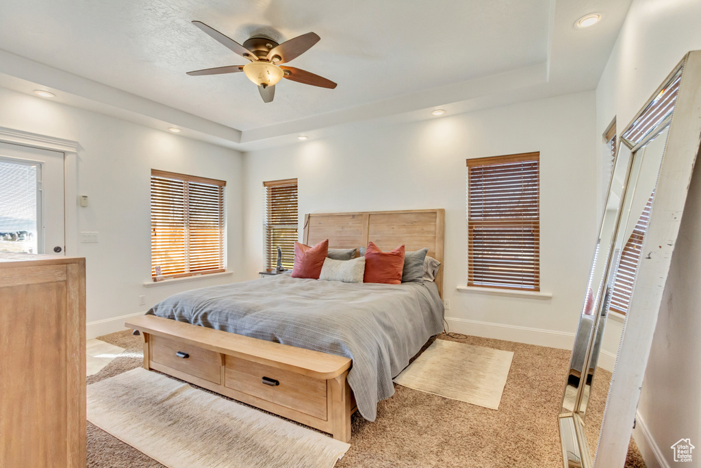 Bedroom featuring a raised ceiling, carpet floors, recessed lighting, and ceiling fan