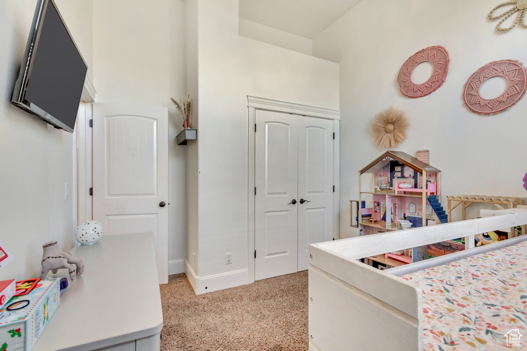 Bedroom with light carpet and a closet