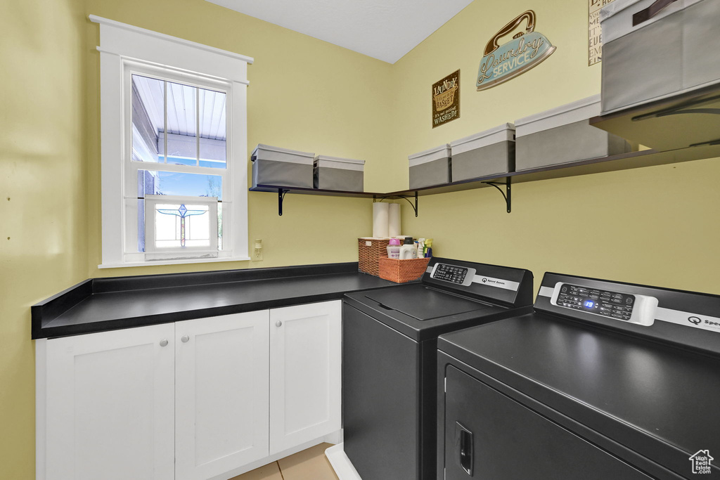 Laundry area featuring washing machine and clothes dryer and cabinet space