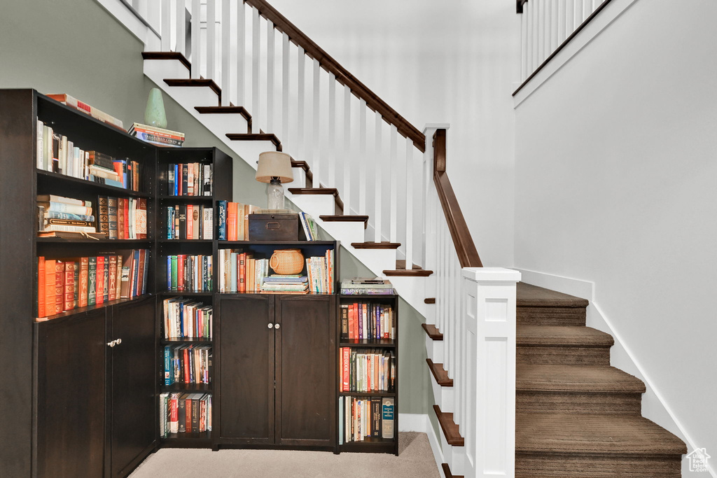 Staircase featuring carpet floors and a towering ceiling
