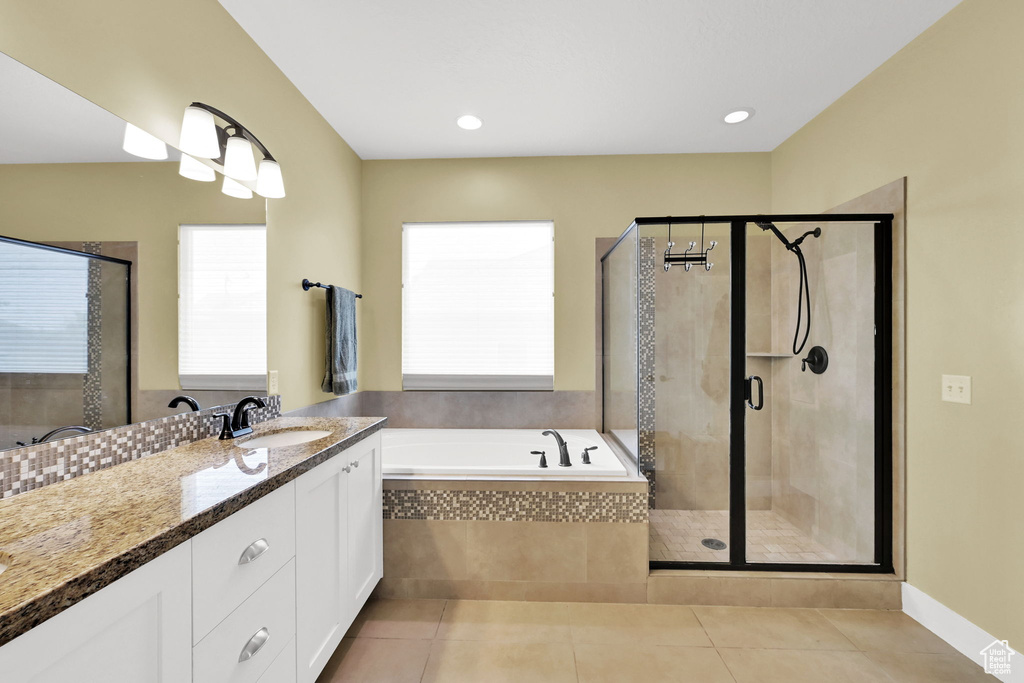 Bathroom with a bath, vanity, plenty of natural light, and a shower stall