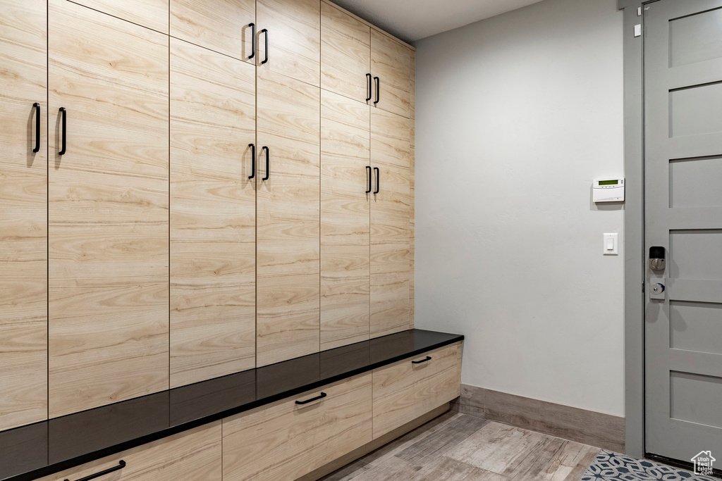 Mudroom featuring wood finished floors and baseboards