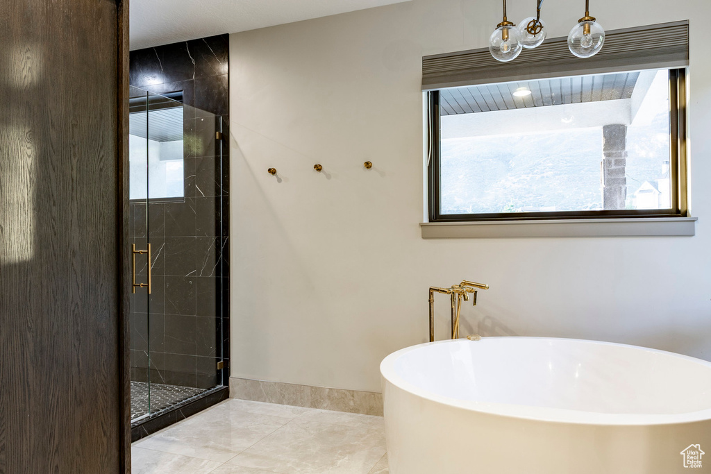 Full bathroom featuring a soaking tub and a shower stall
