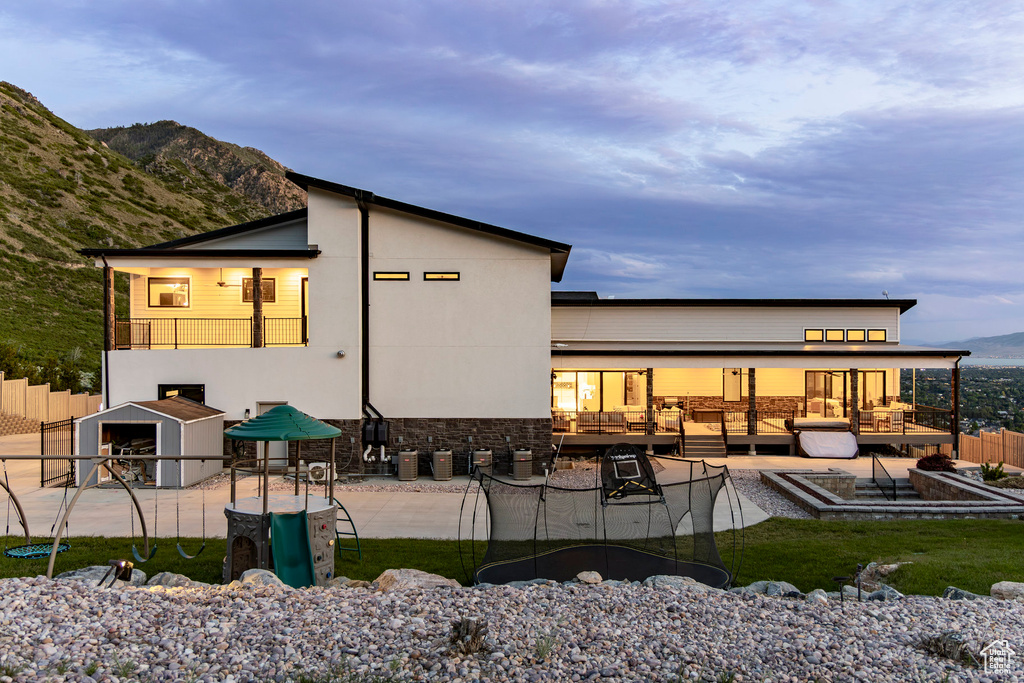 Back of property featuring a mountain view and a patio