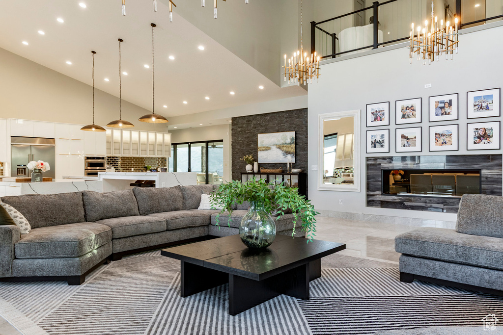 Living area with high vaulted ceiling, a chandelier, and recessed lighting