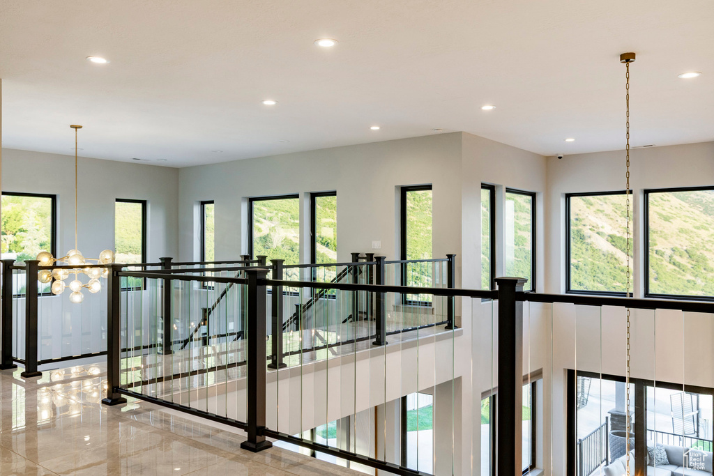 Hall with recessed lighting, a chandelier, and an upstairs landing