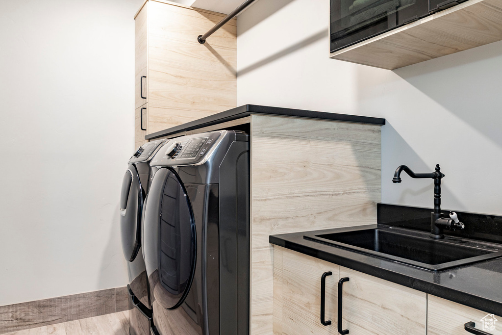 Laundry area featuring separate washer and dryer and cabinet space