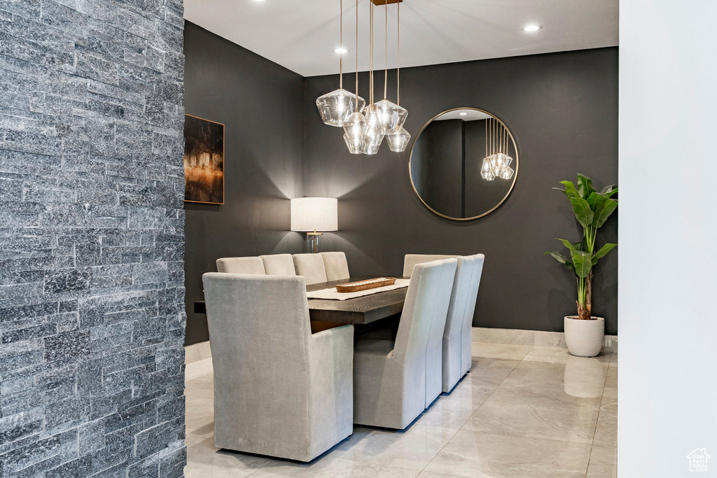 Dining room featuring a chandelier, marble finish floors, an accent wall, and recessed lighting