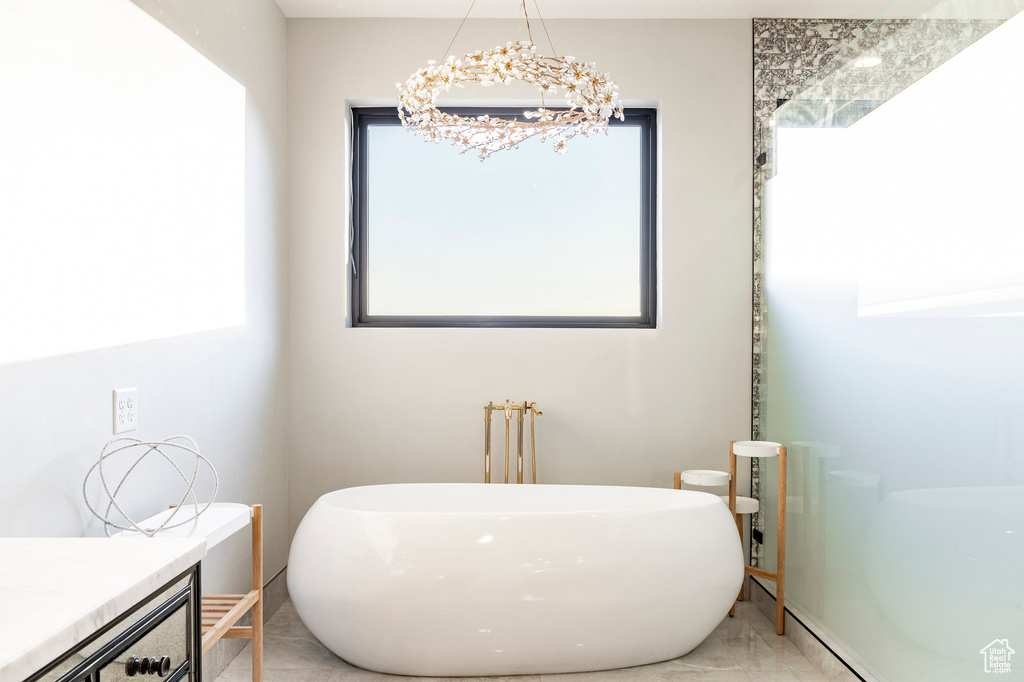 Bathroom with a freestanding bath and a chandelier