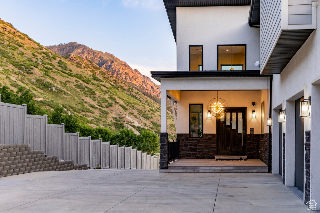 Doorway to property with stucco siding, stone siding, and a mountain view