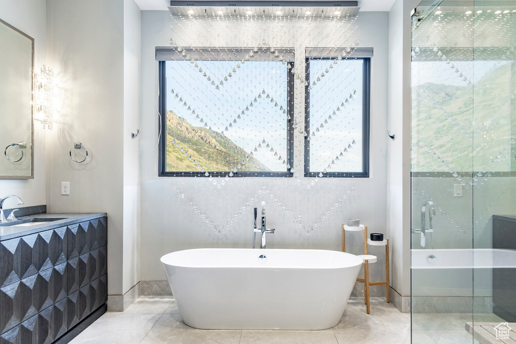 Full bathroom with a soaking tub, vanity, tile patterned flooring, and a stall shower