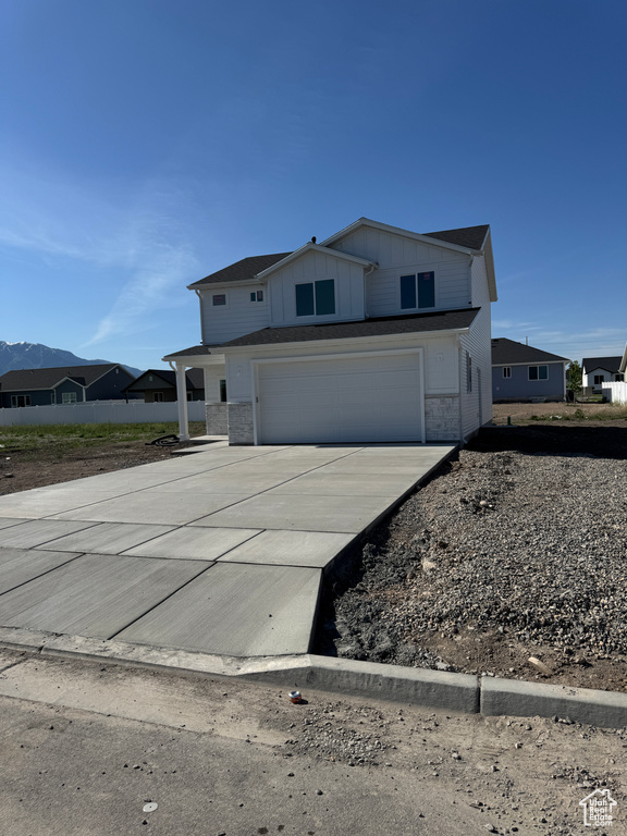 View of front of property with concrete driveway, a garage, and board and batten siding
