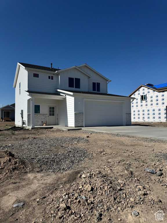 View of front of property featuring concrete driveway, a garage, and board and batten siding