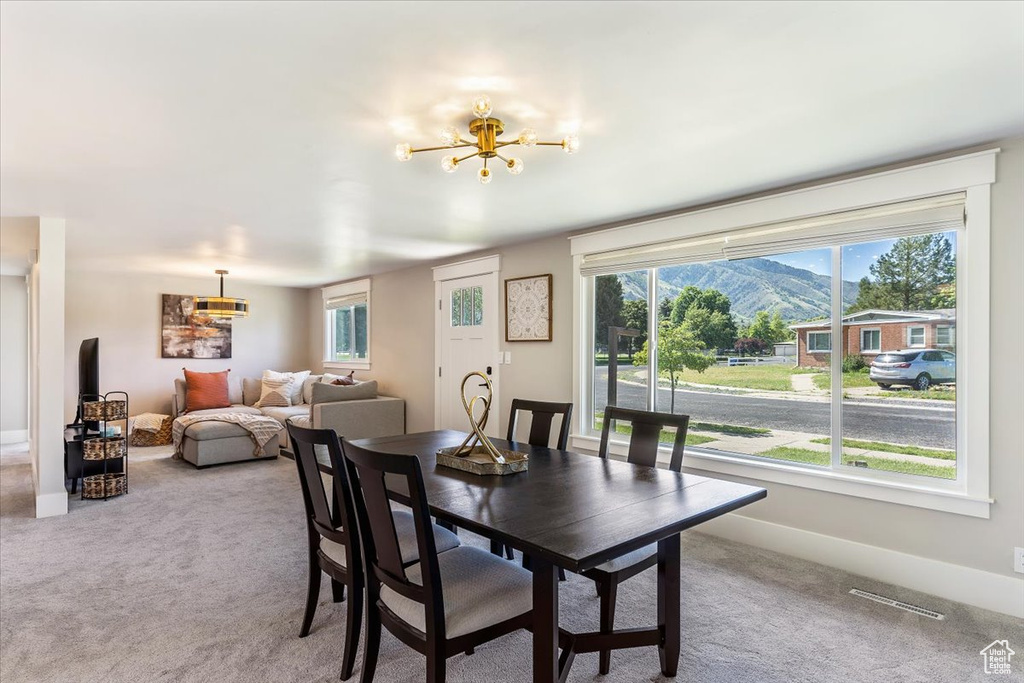 Dining space featuring a chandelier, carpet, healthy amount of natural light, and a mountain view