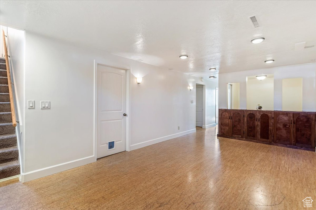 Unfurnished living room with stairway and light wood finished floors