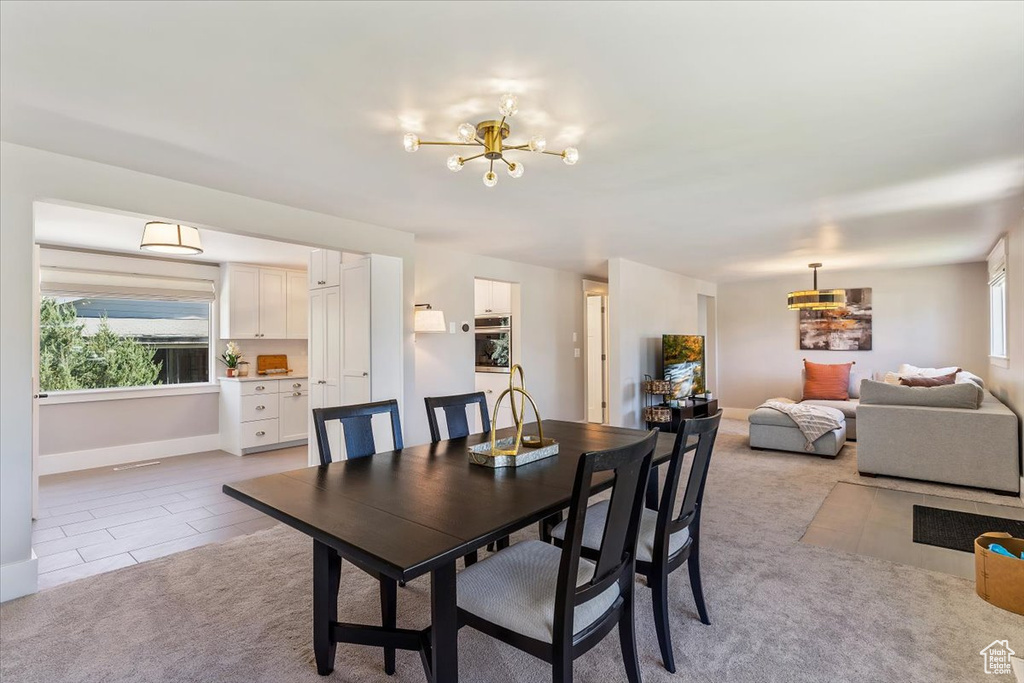 Dining room featuring a chandelier and light carpet