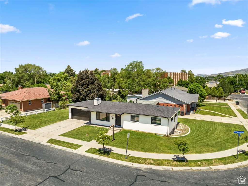 View of front of property featuring concrete driveway and a front yard