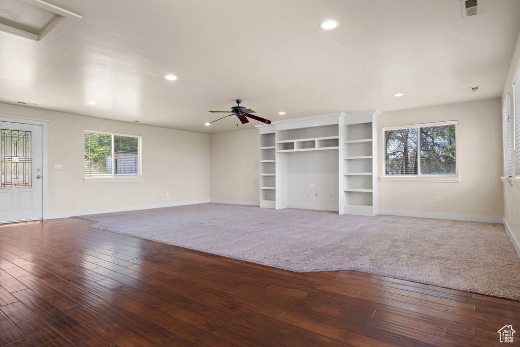Unfurnished living room featuring healthy amount of natural light, ceiling fan, recessed lighting, and hardwood / wood-style floors