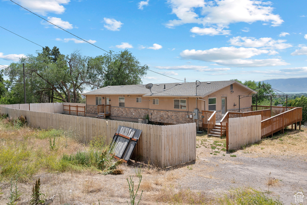 Back of property with a deck and stucco siding