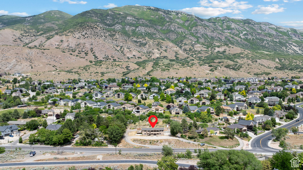Aerial view of property and surrounding area featuring a mountain backdrop