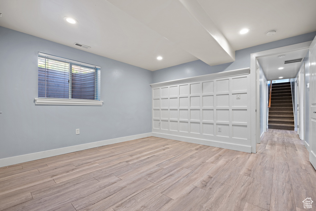 Spare room with stairs, light wood finished floors, a smoke detector, and recessed lighting