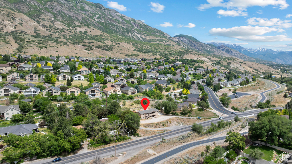 Aerial overview of property's location featuring a mountainous background and nearby suburban area