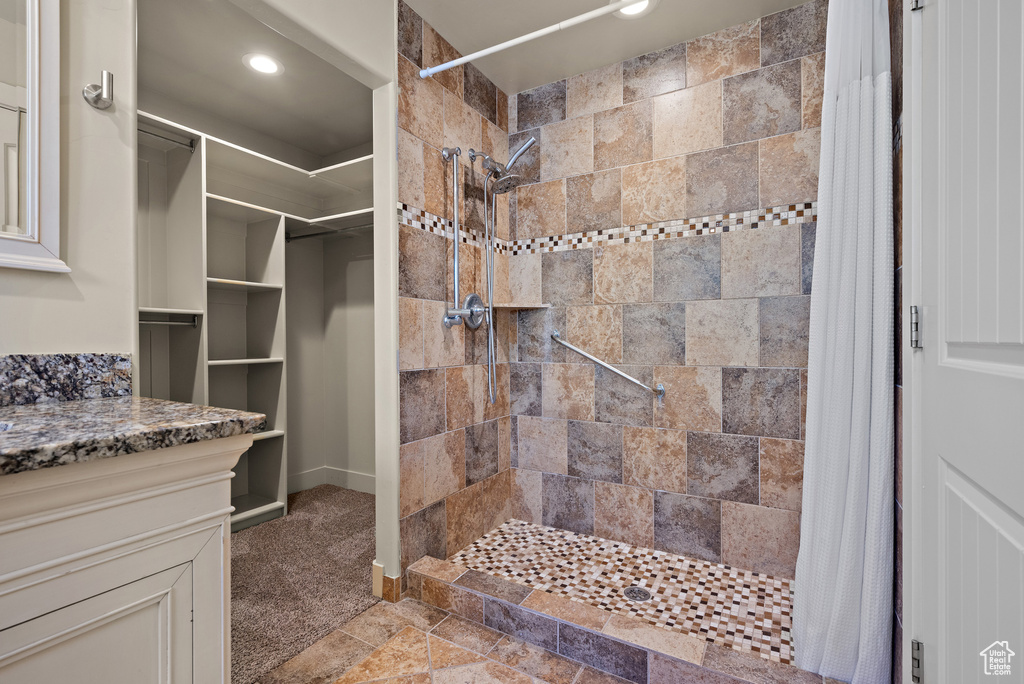 Full bath featuring a tile shower, vanity, a closet, and recessed lighting