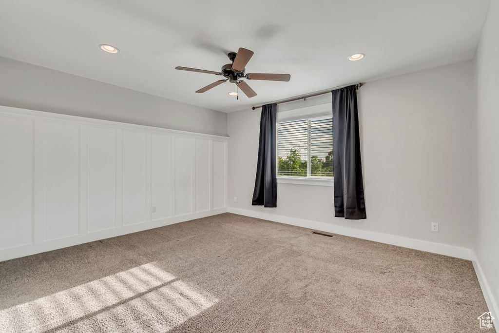Carpeted empty room featuring a ceiling fan and recessed lighting