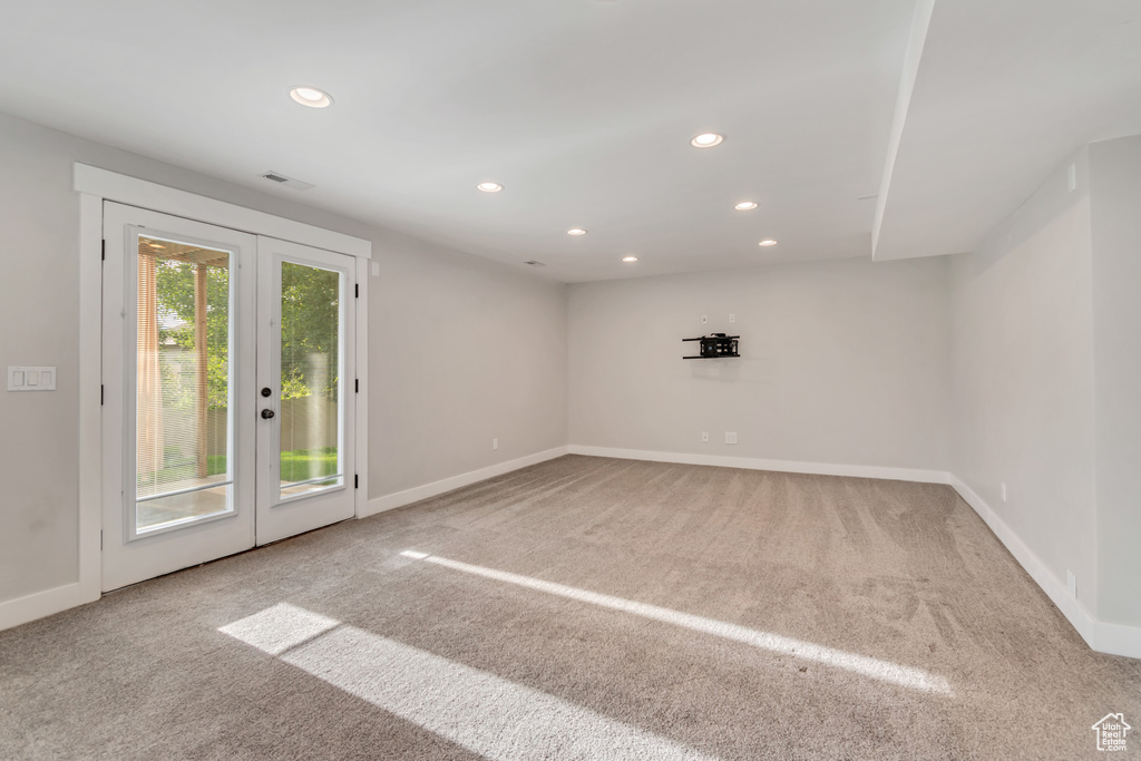Carpeted empty room with french doors and recessed lighting