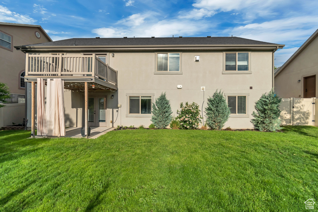 Rear view of house with stucco siding and a wooden deck