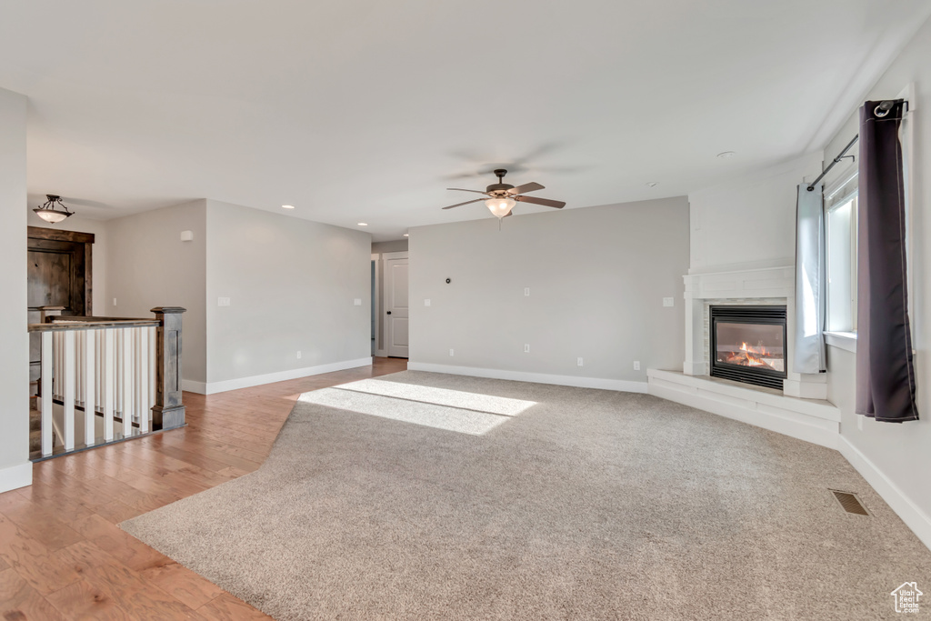 Unfurnished living room featuring recessed lighting, a ceiling fan, a glass covered fireplace, and light wood finished floors