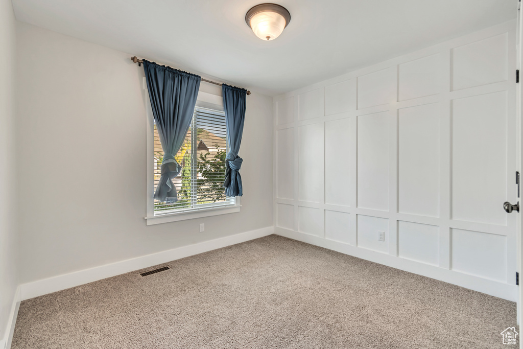 Carpeted spare room with baseboards
