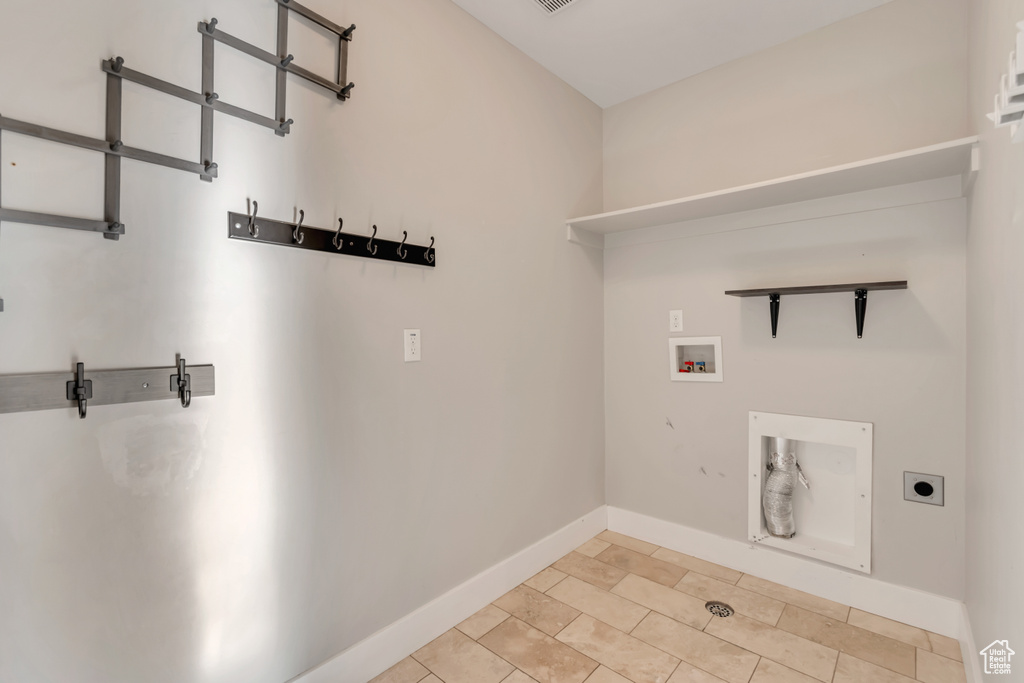 Laundry room with hookup for a washing machine, electric dryer hookup, and light tile patterned flooring