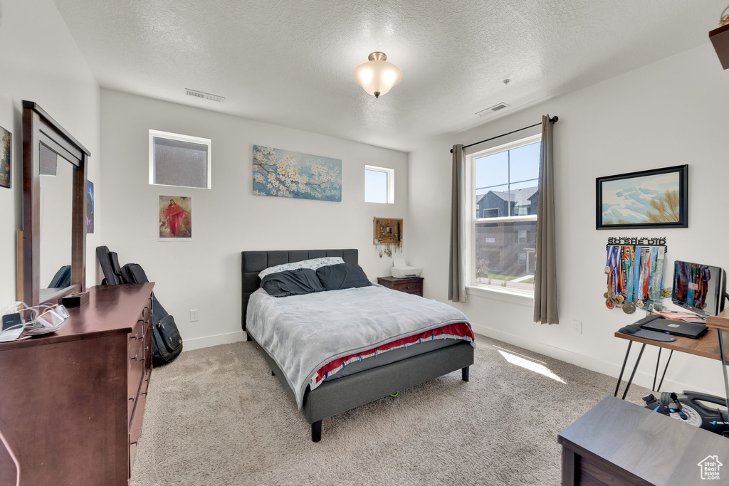 Bedroom featuring a textured ceiling and carpet