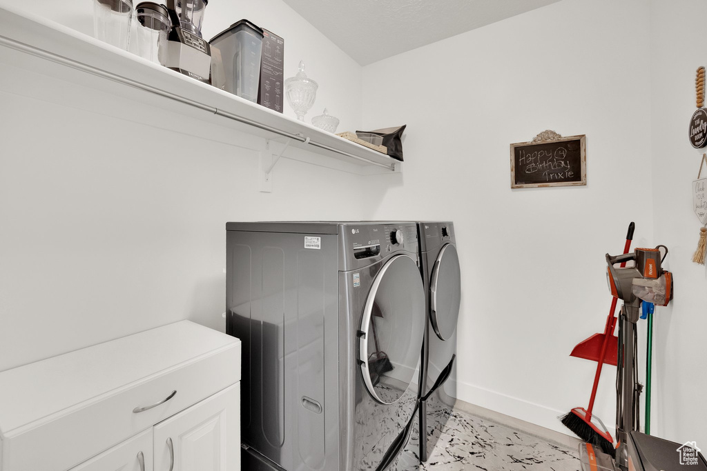 Laundry room featuring separate washer and dryer and cabinet space