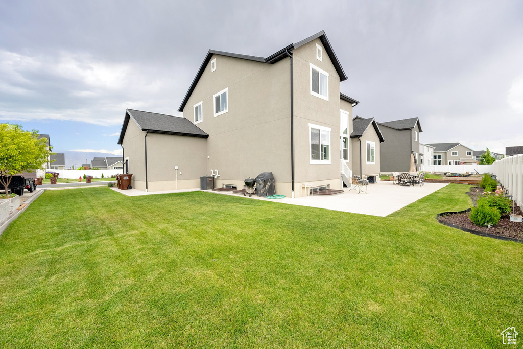 Rear view of property with a patio, stucco siding, and a residential view