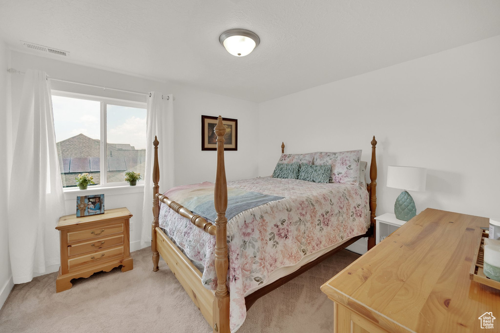 Bedroom featuring light colored carpet and baseboards