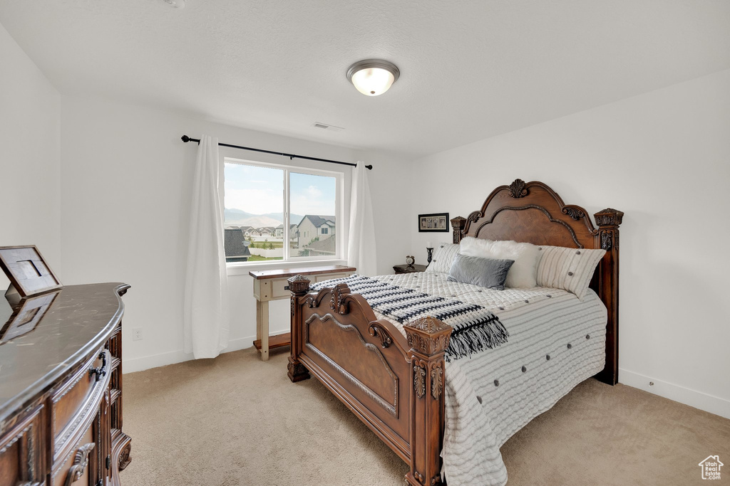 Bedroom featuring light carpet