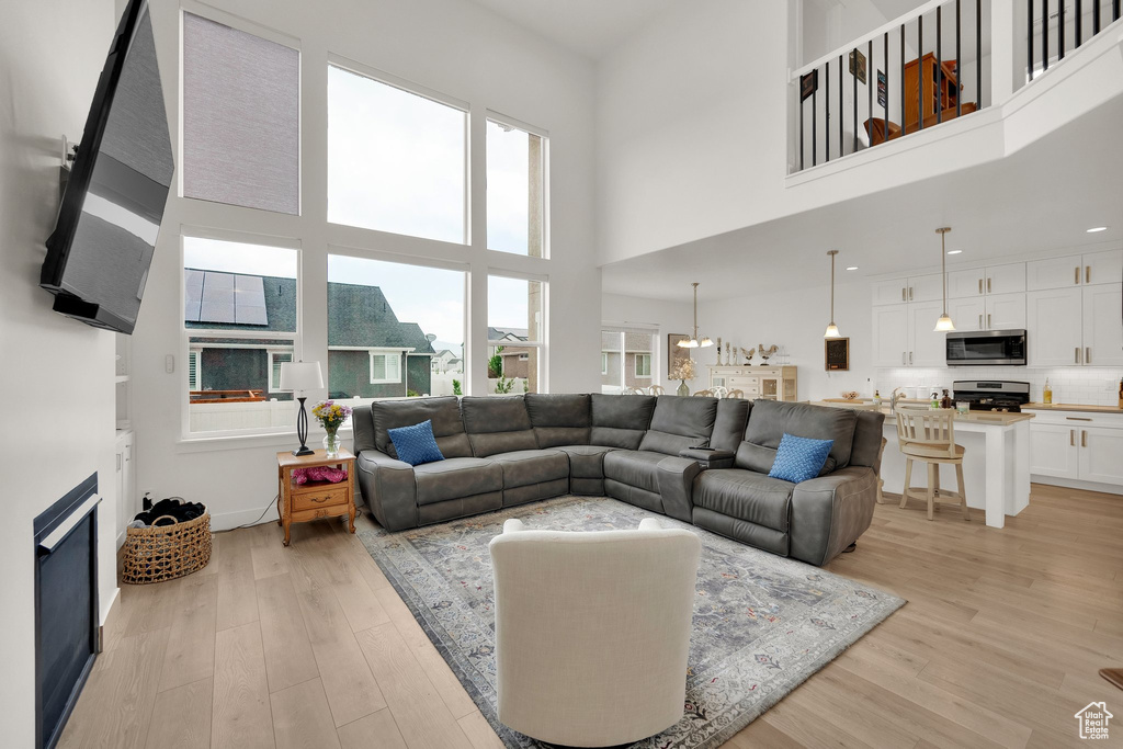 Living area with light wood-style floors and a towering ceiling