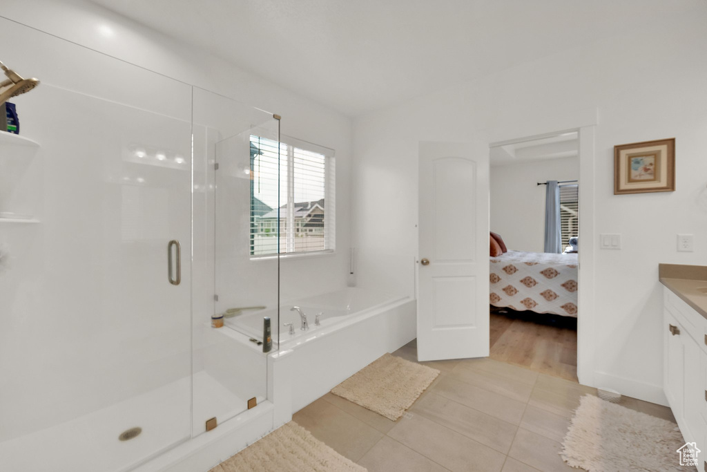 Bathroom with vanity, a bath, a shower stall, tile patterned flooring, and ensuite bath