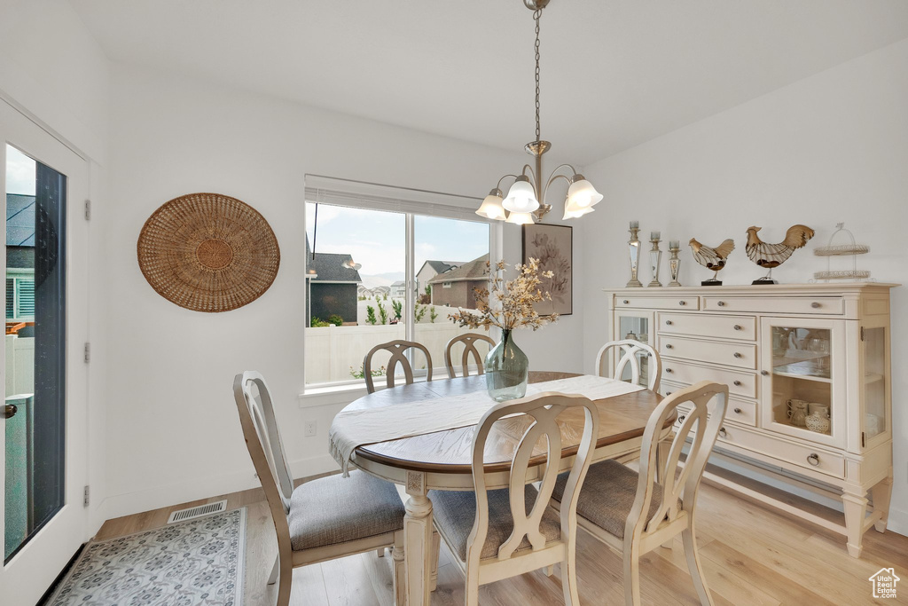 Dining space with light wood-style flooring and a chandelier