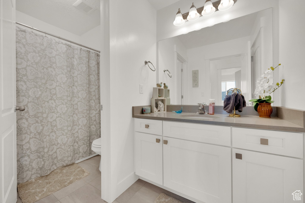 Full bath with vanity, tile patterned floors, and a shower with shower curtain