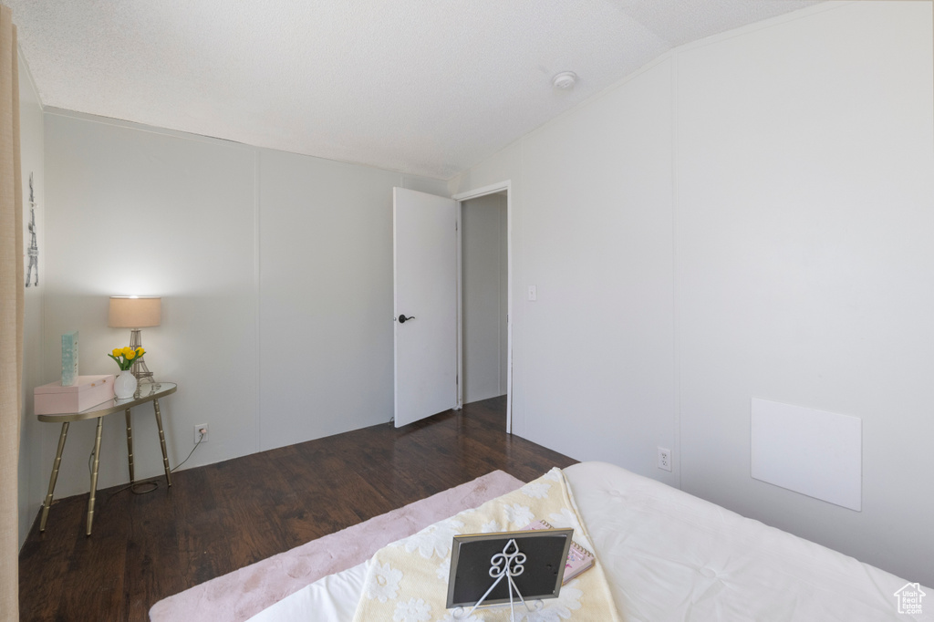 Bedroom with wood finished floors and vaulted ceiling