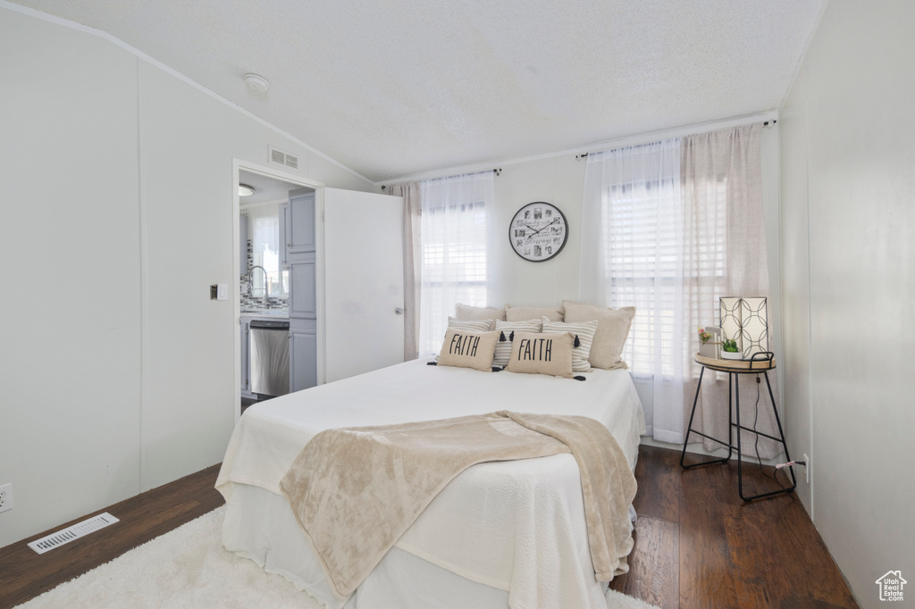 Bedroom featuring vaulted ceiling and dark wood-style floors