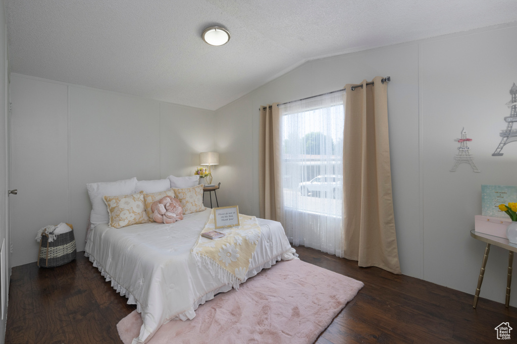 Bedroom featuring wood finished floors and lofted ceiling