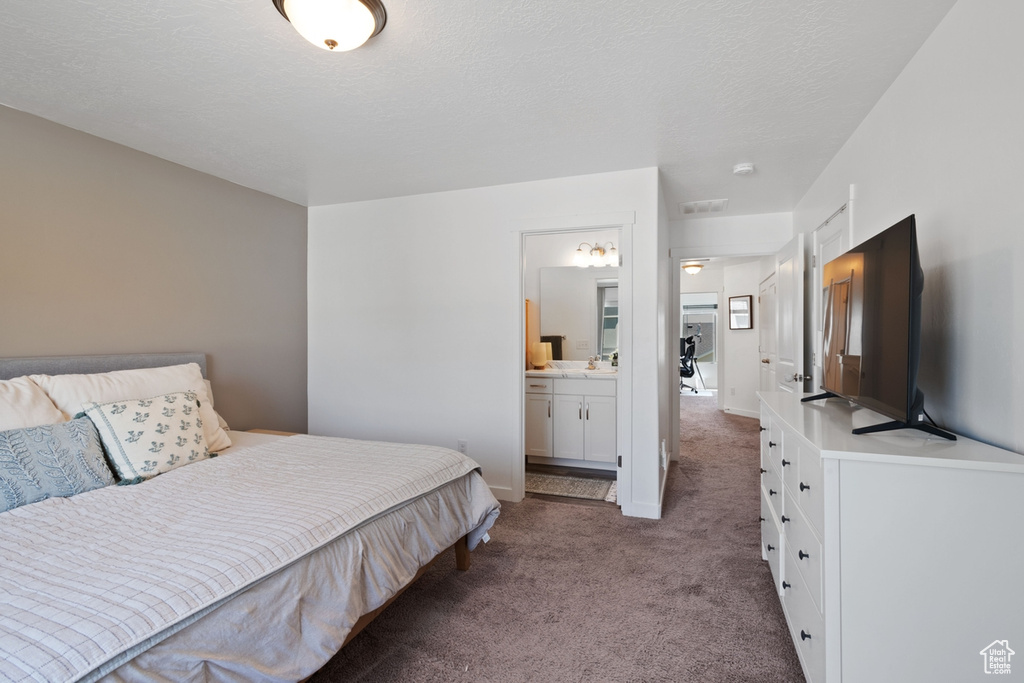 Carpeted bedroom featuring ensuite bath