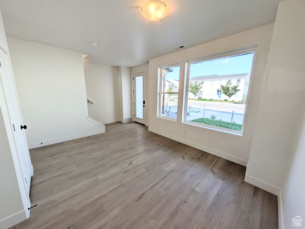 Empty room featuring light wood-type flooring and a smoke detector