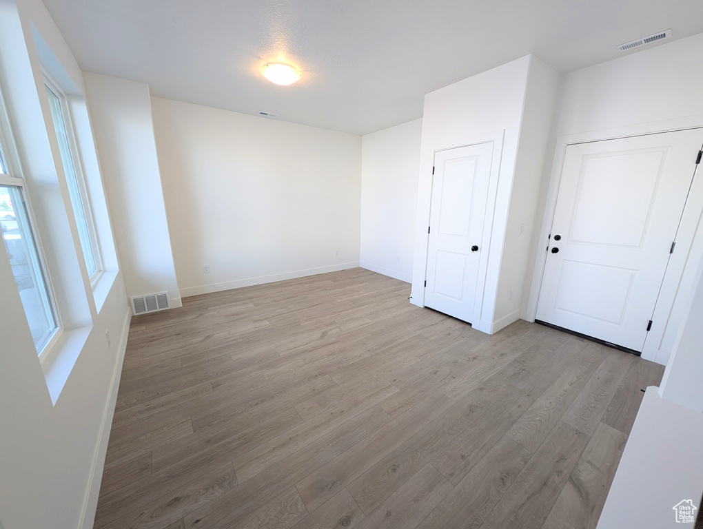Spare room featuring light wood finished floors and baseboards