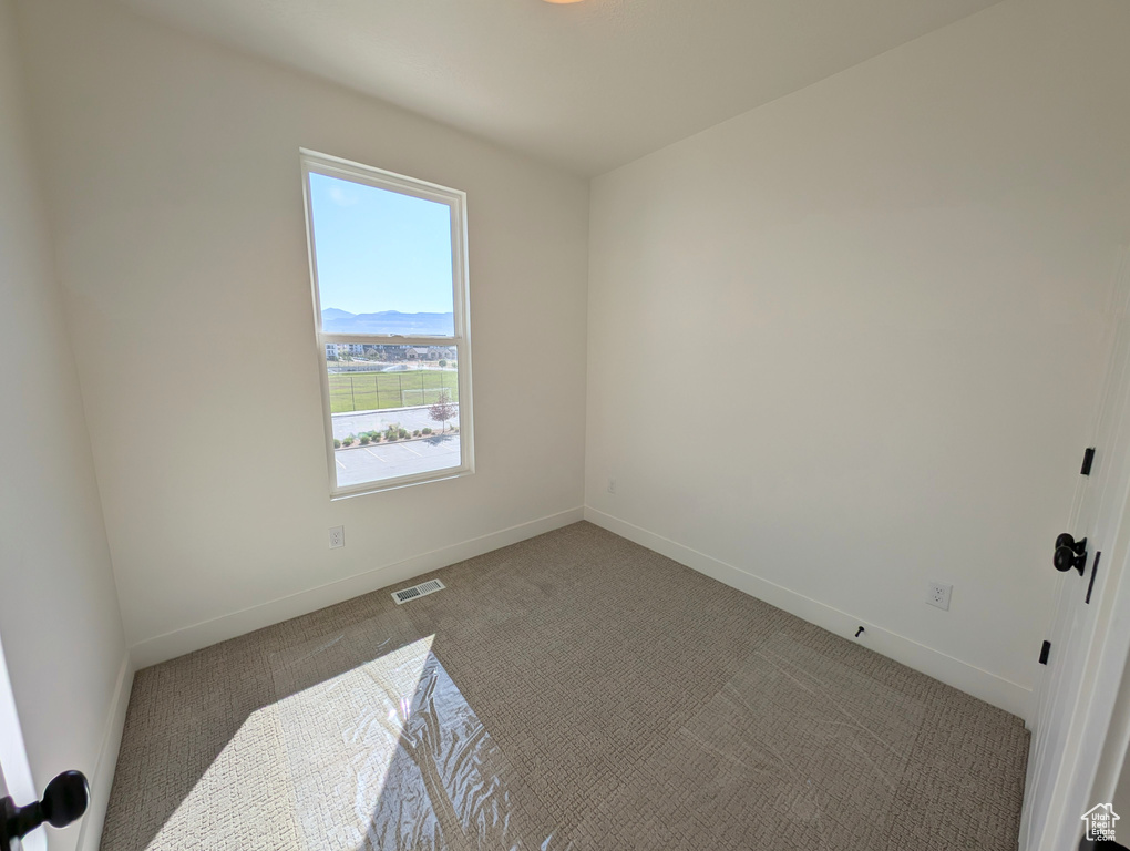 Empty room with carpet flooring and baseboards