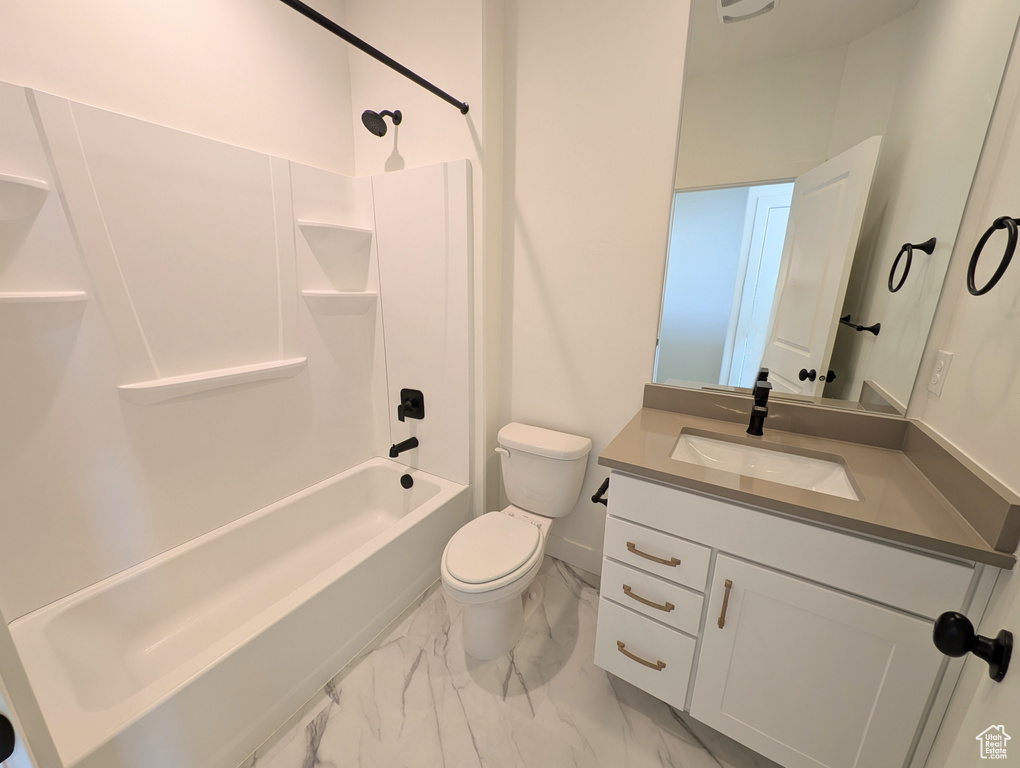 Bathroom featuring marble finish floors, vanity, and shower / tub combination
